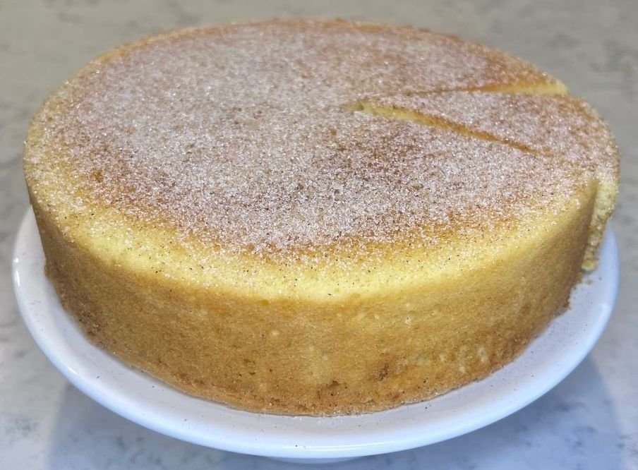 Snickerdoodle cake recipe featuring a whole cinnamon cake topped with buttery cinnamon sugar