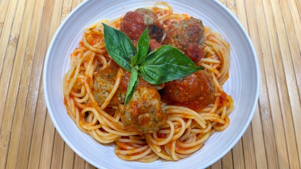 Plate with spaghetti and meatballs with tomato sauce.