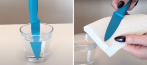placing a knife in hot water and drying it to remove excess buttercream from cake