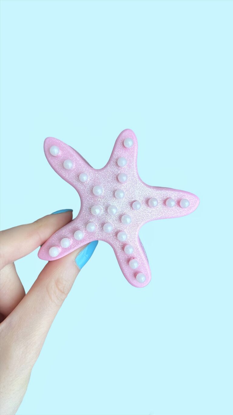 Fingers holding a starfish cake