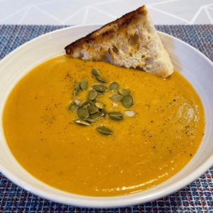 plate with red lentils soup made fresh at home and a piece of bread