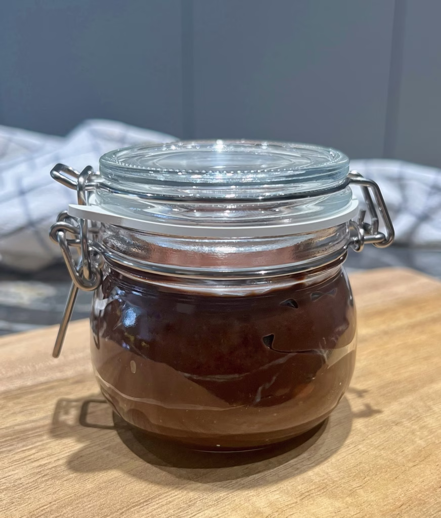 Jar of chocolate fudge sauce closed and ready for storage in the fridge