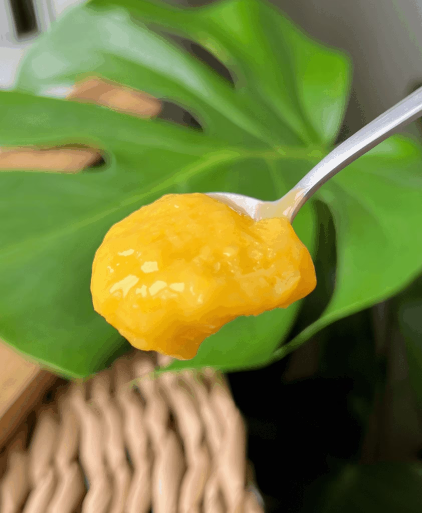 Close-up of mango sherbet on a spoon showing smooth sorbet texture