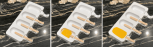 Mango sherbet poured into popsicle molds with sticks inserted before freezing