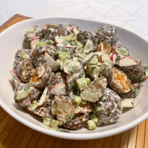 A bowl of roasted potato salad made with red potatoes