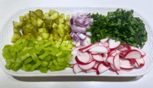 chopped vegetables including celery, onion, pickles, parsley and chives