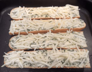 grated mozarella cheese added to garlix bread baguette