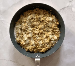 adding parmesan cheese to cooked tuna in a pan