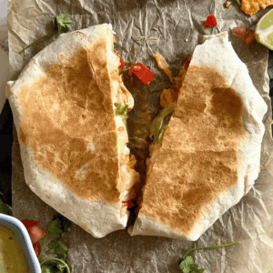 chicken crunchwrap on a plate split in half showing crunch and cheese