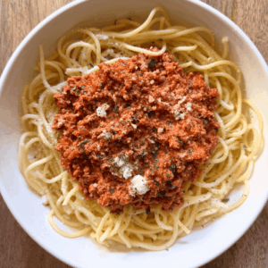 bolognese on top of spaghetti in a bowl