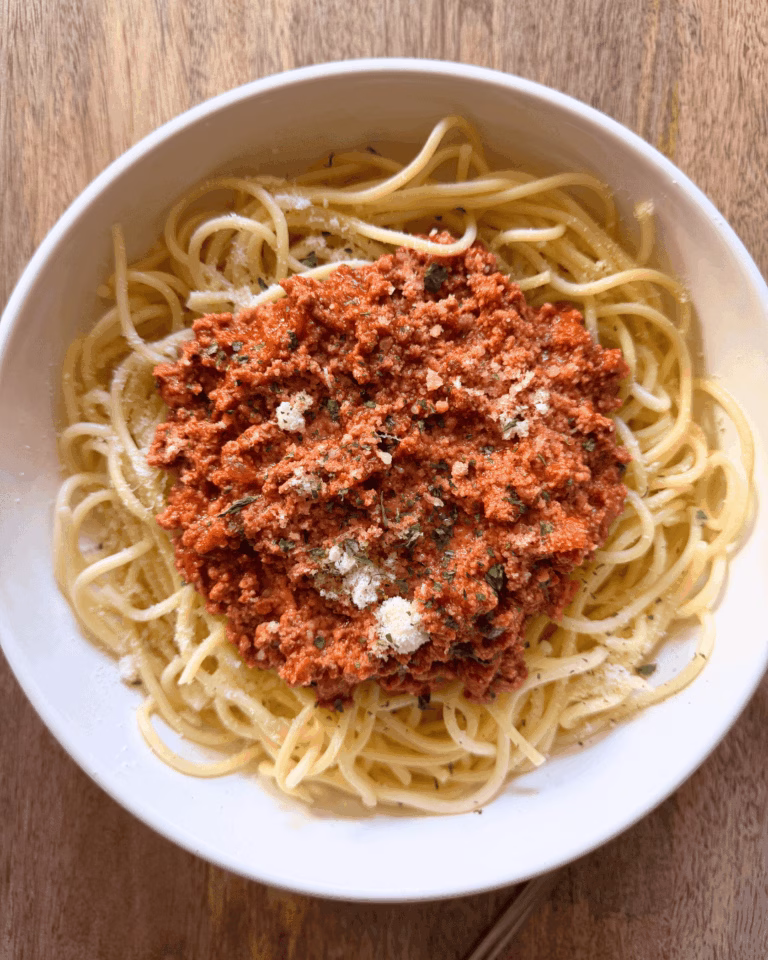 bolognese on top of spaghetti in a bowl