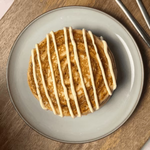 cinnamon roll pancakes on a plate top view with cream cheese glaze