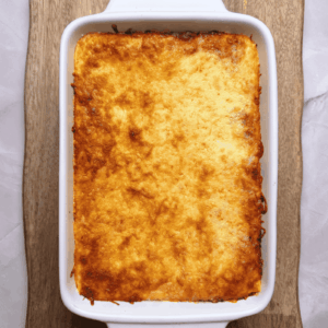 Homemade lasagna fresh out of the oven in a baking dish with cheese on top