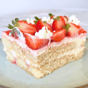 Creamy slice of strawberry tiramisu showing layers of mascarpone, ladyfingers, and strawberry puree.