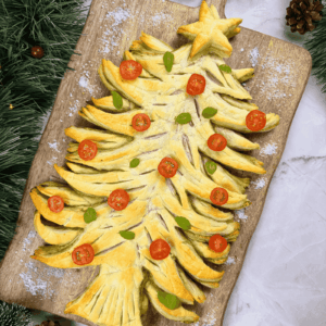 Overhead view of a baked puff pastry Christmas tree filled with pesto, an easy Christmas appetizer.