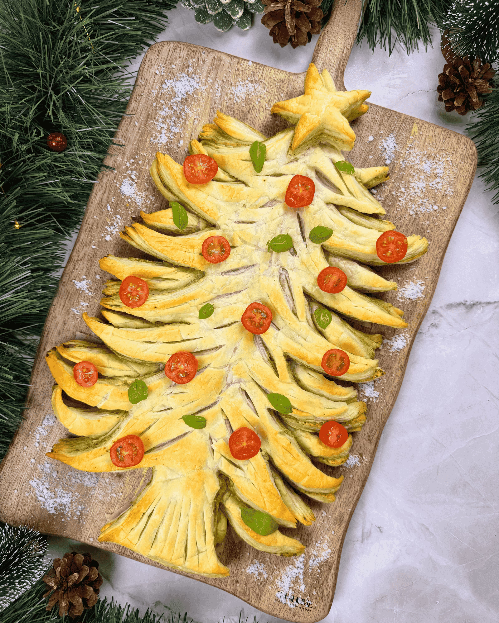 Overhead view of a baked puff pastry Christmas tree filled with pesto, an easy Christmas appetizer.
