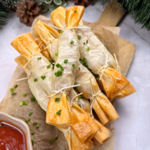 Cheesy phyllo hot dog crackers arranged on a plate shaped like Christmas crackers.