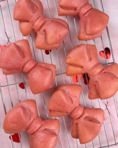 pink brioche bows freshly baked on a cooling rack