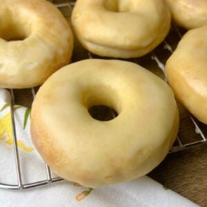 Close up shot of a sourdough donuts showing the shiny vanilla glaze and golden brown crust.