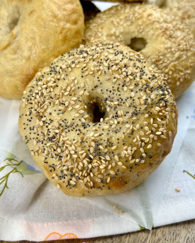 close up of sourdough bagel recipe covered with sesame seeds and poppy seeds