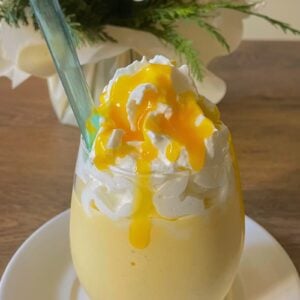 cream mango milkshake recipe made with only 3 ingredients at home topped with whipped cream and mango pulp